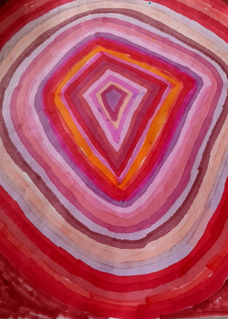 A concentric circular pattern composed of varied shades of pink, red, and orange, creating a visually striking watercolor effect.